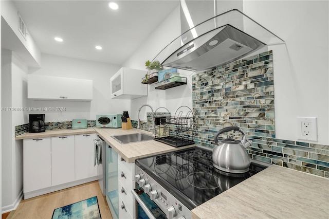 kitchen featuring light wood-type flooring, white cabinetry, sink, and stainless steel range oven