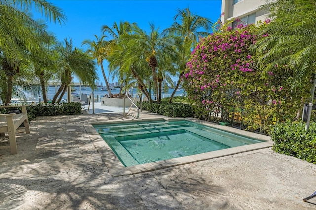 view of pool featuring an in ground hot tub and a water view