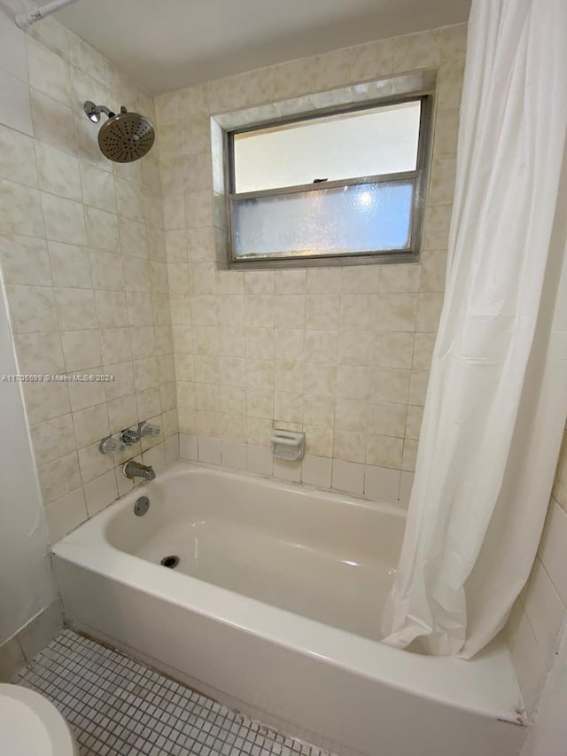 bathroom with shower / bath combo with shower curtain, toilet, plenty of natural light, and tile patterned flooring