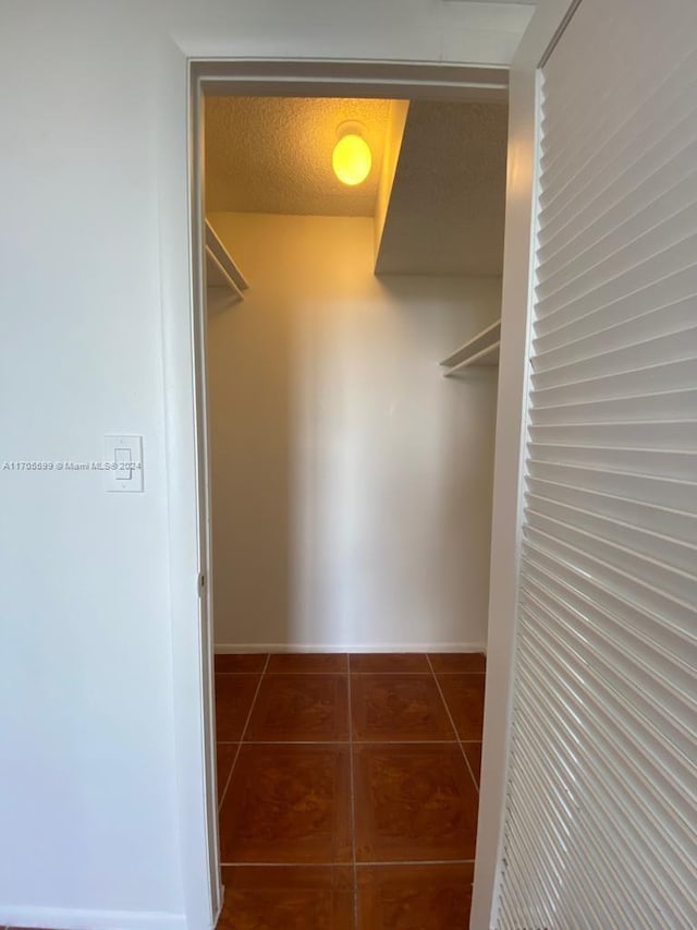 walk in closet featuring dark tile patterned flooring