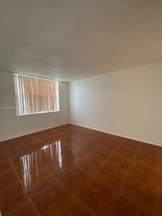 unfurnished room featuring a textured ceiling