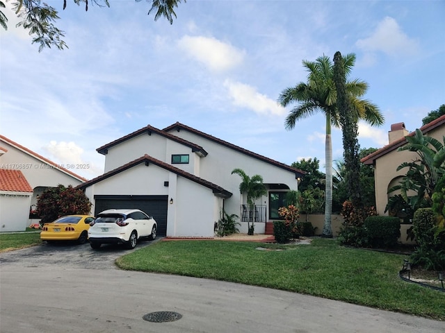 view of front of house with a front lawn, aphalt driveway, and stucco siding