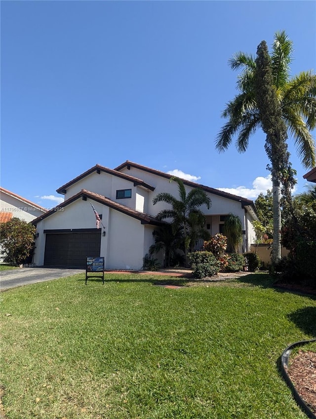 view of front of property featuring aphalt driveway, a garage, a front lawn, and stucco siding