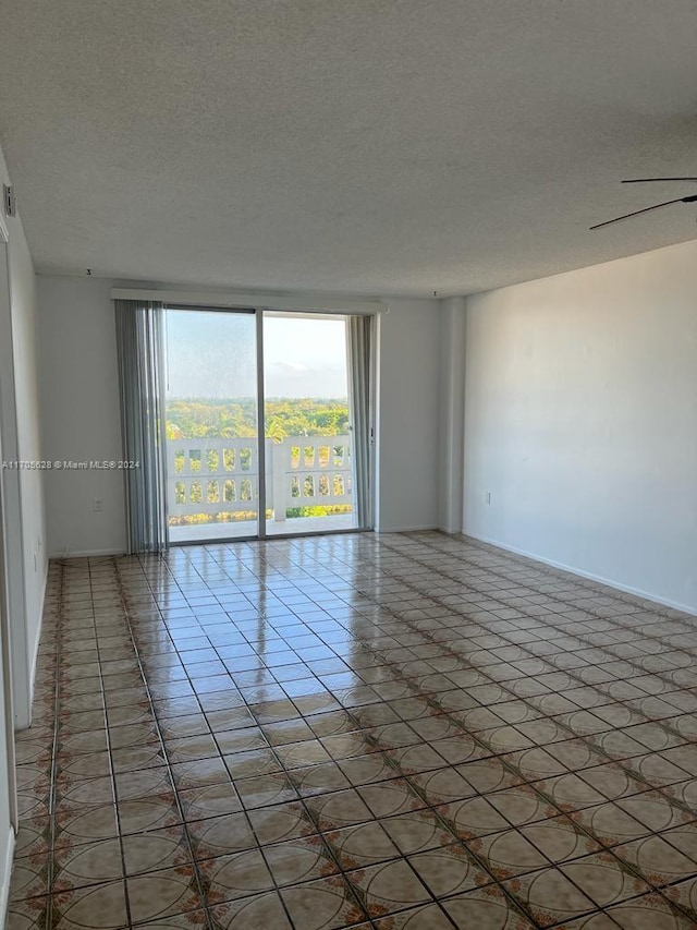 unfurnished room with tile patterned flooring, a textured ceiling, and ceiling fan