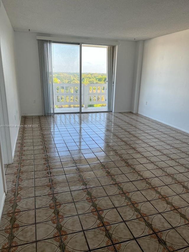 tiled empty room with a textured ceiling