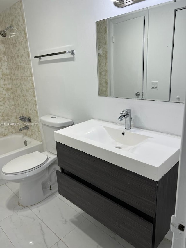 full bathroom with toilet, vanity, and tiled shower / bath