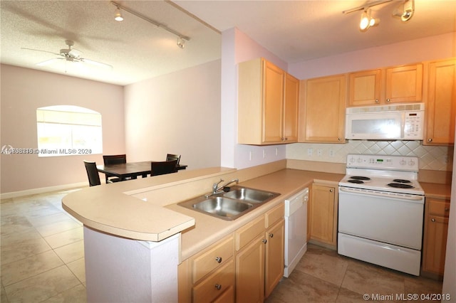 kitchen with kitchen peninsula, rail lighting, a textured ceiling, white appliances, and sink