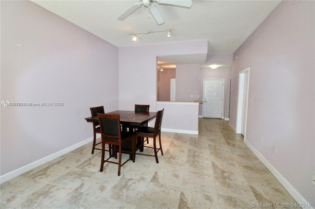 dining area with a textured ceiling and ceiling fan