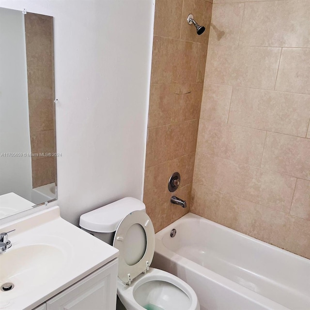 full bathroom with vanity, tiled shower / bath combo, and toilet