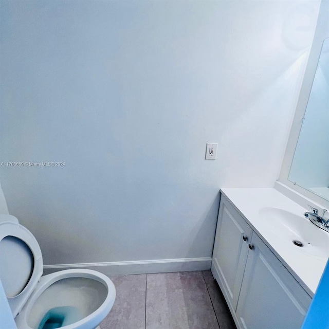 bathroom with tile patterned flooring, vanity, and toilet