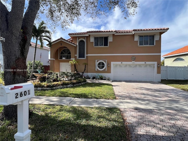 mediterranean / spanish-style house featuring a garage and a front yard