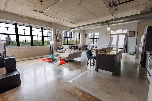 living room with sink, concrete flooring, and french doors