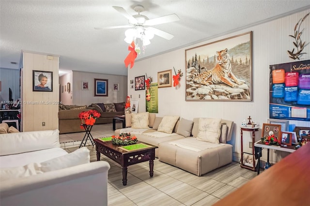 living room featuring ceiling fan, light tile patterned floors, and a textured ceiling