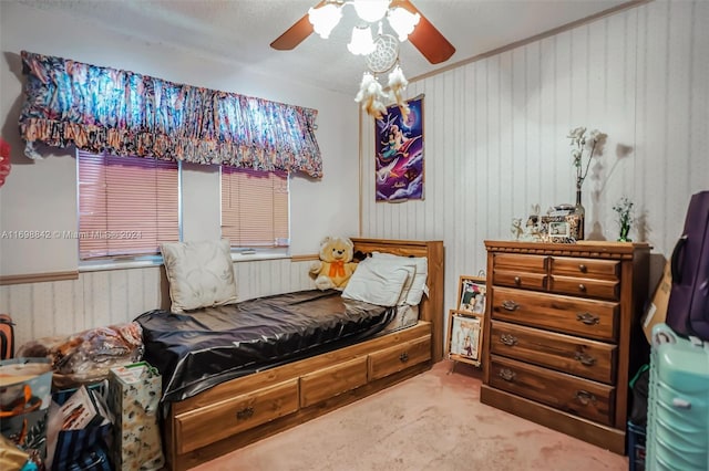 carpeted bedroom with ceiling fan and a textured ceiling