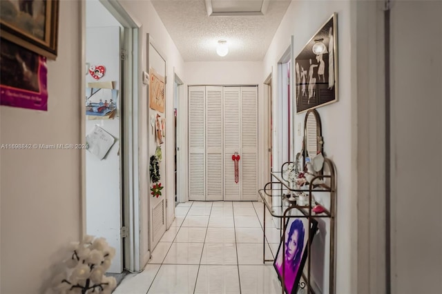 hall with light tile patterned floors and a textured ceiling