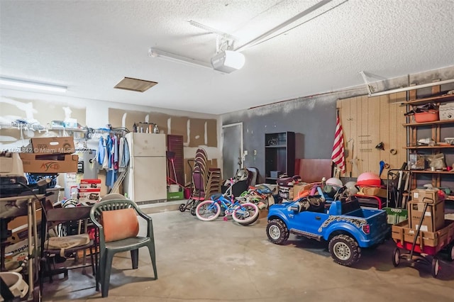 garage featuring white fridge and a garage door opener