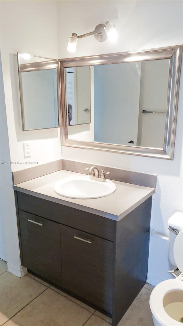 bathroom with tile patterned flooring, vanity, and toilet