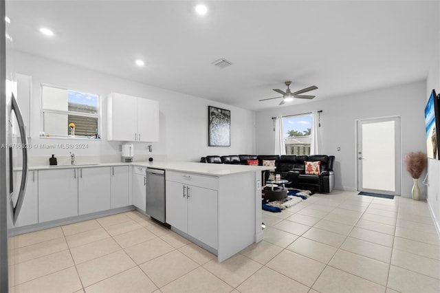 kitchen featuring white cabinetry, ceiling fan, kitchen peninsula, light tile patterned floors, and appliances with stainless steel finishes