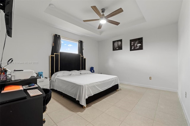 bedroom with light tile patterned floors, baseboards, a raised ceiling, and ceiling fan