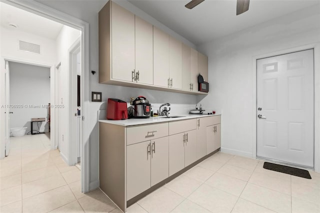 kitchen with a sink, visible vents, light tile patterned floors, and light countertops