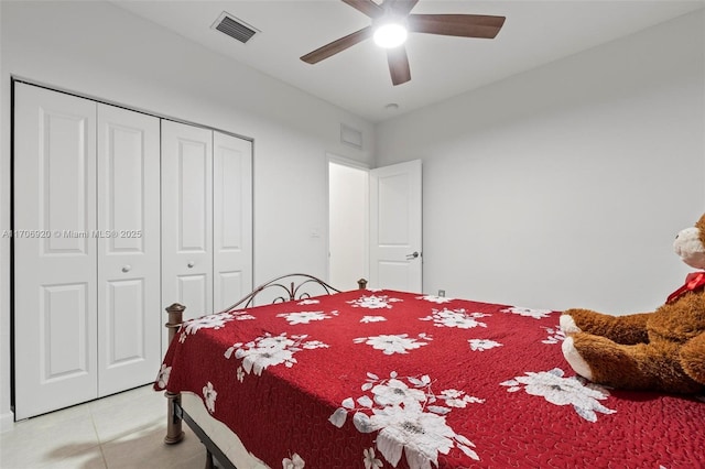 bedroom featuring light tile patterned floors, visible vents, a closet, and ceiling fan