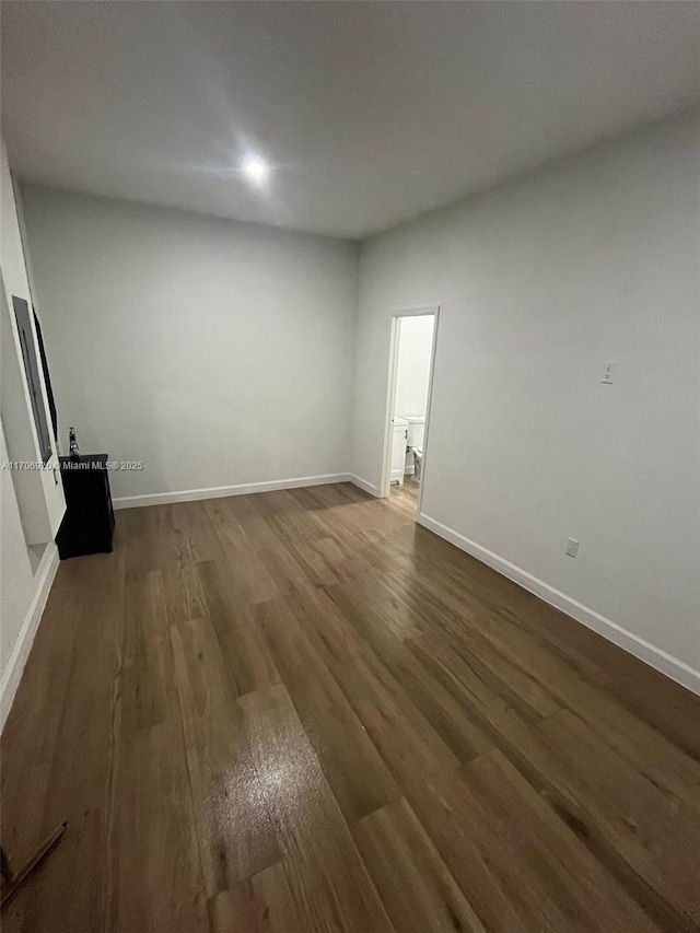 empty room with baseboards and dark wood finished floors