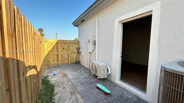 view of home's exterior featuring ac unit, stucco siding, a gate, fence, and cooling unit