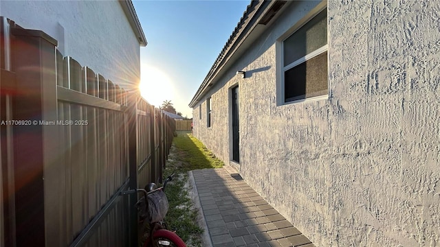 view of property exterior with stucco siding and fence