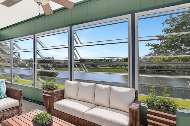 sunroom / solarium featuring a water view and ceiling fan