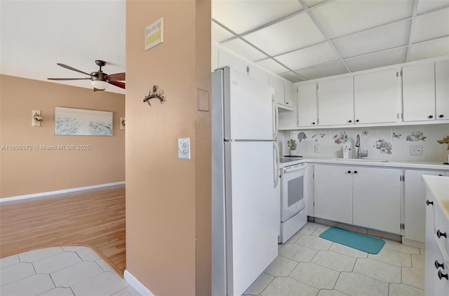 kitchen with white appliances, white cabinetry, sink, light tile patterned flooring, and ceiling fan