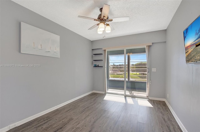 spare room featuring ceiling fan, dark hardwood / wood-style floors, and a textured ceiling