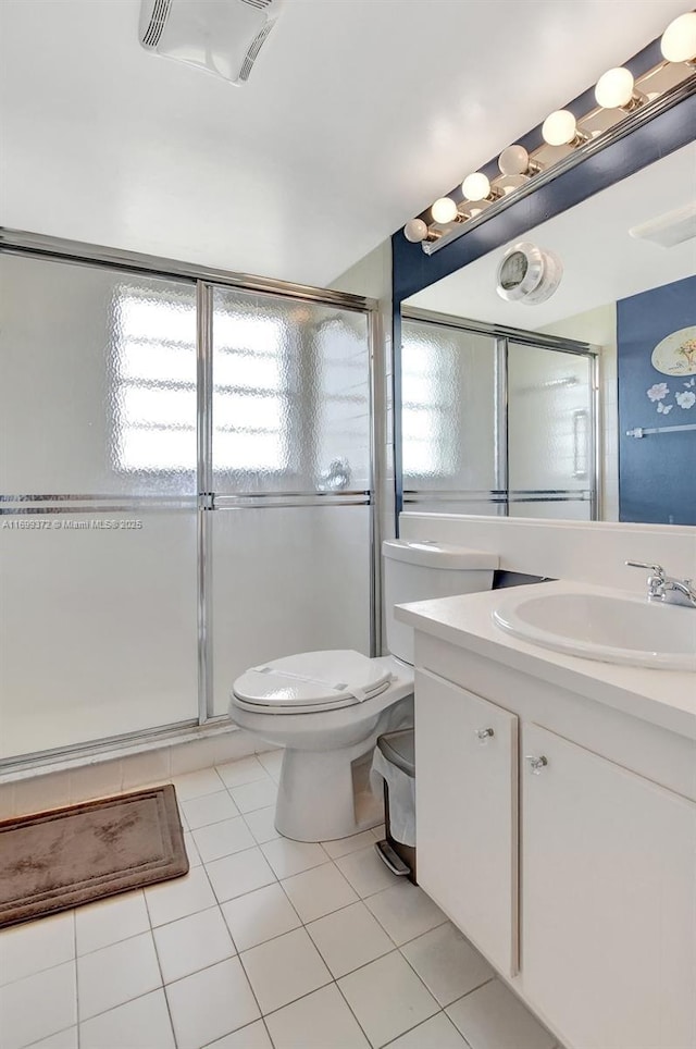 bathroom with vanity, toilet, a shower with door, and tile patterned flooring