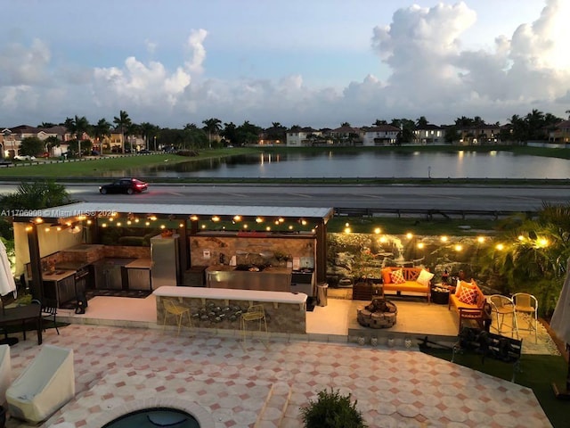 patio terrace at dusk with a bar and a water view