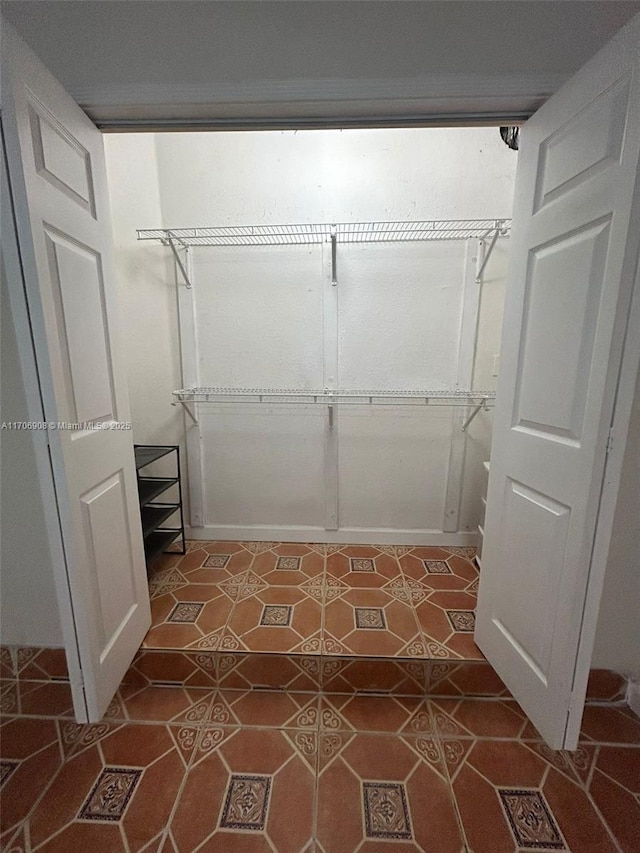 walk in closet with dark tile patterned flooring