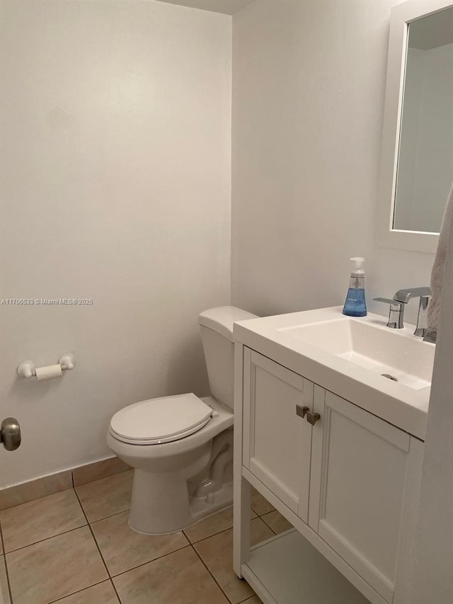 bathroom with toilet, tile patterned flooring, and vanity