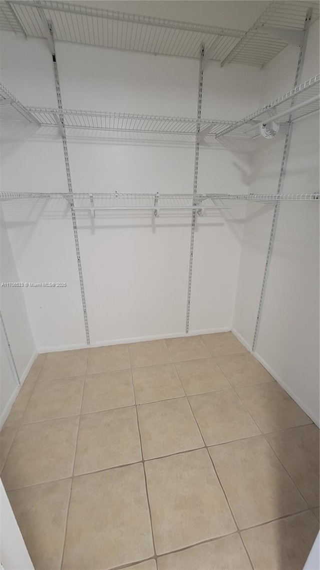 walk in closet with tile patterned floors