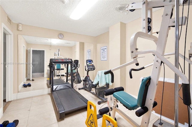 exercise room featuring light tile patterned flooring and a textured ceiling