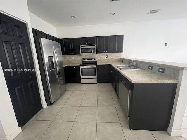 kitchen featuring decorative backsplash, sink, light tile patterned flooring, and appliances with stainless steel finishes