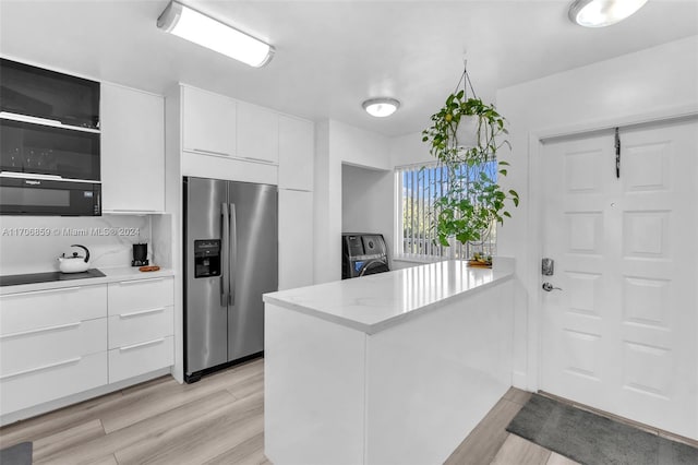 kitchen featuring white cabinets, light hardwood / wood-style floors, kitchen peninsula, and black appliances