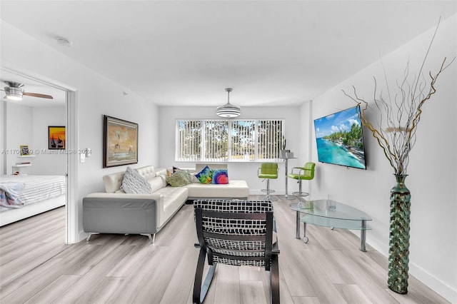 living room featuring ceiling fan, breakfast area, and light hardwood / wood-style floors