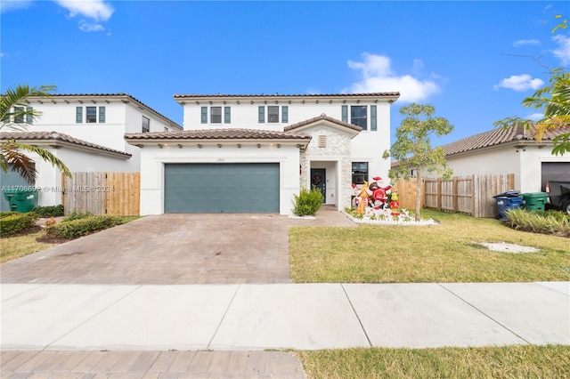 mediterranean / spanish-style house featuring a garage and a front lawn