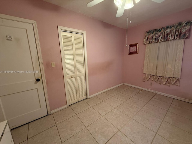 unfurnished bedroom with light tile patterned flooring, ceiling fan, and a closet