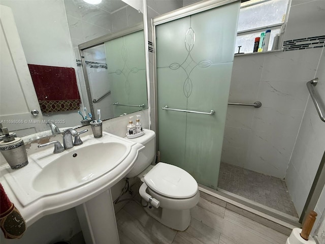 bathroom featuring toilet and an enclosed shower