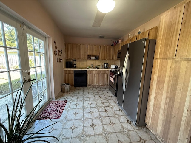 kitchen with appliances with stainless steel finishes, sink, and decorative backsplash