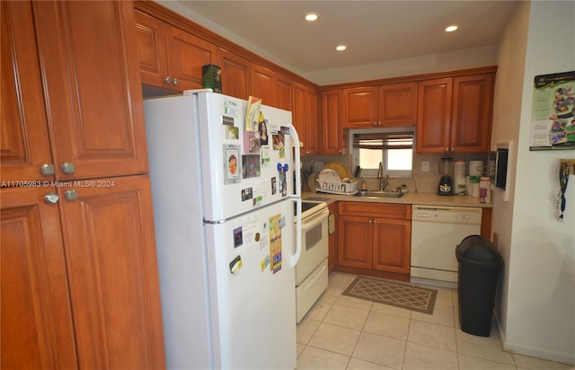 kitchen with tasteful backsplash, sink, light tile patterned floors, and white appliances