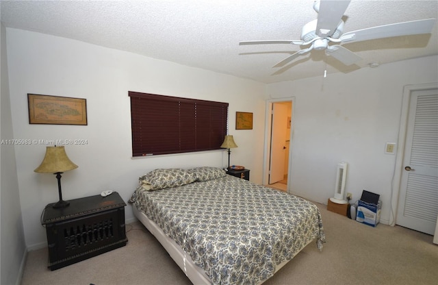 bedroom featuring ceiling fan, carpet floors, and a textured ceiling