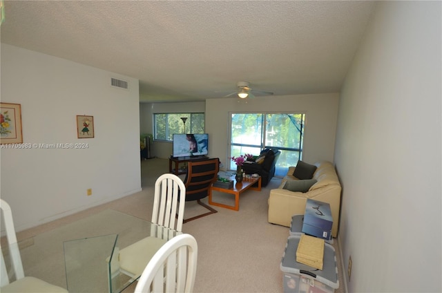 carpeted living room featuring a textured ceiling and ceiling fan