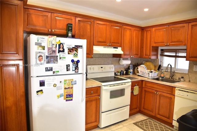 kitchen featuring backsplash, sink, light tile patterned flooring, and white appliances