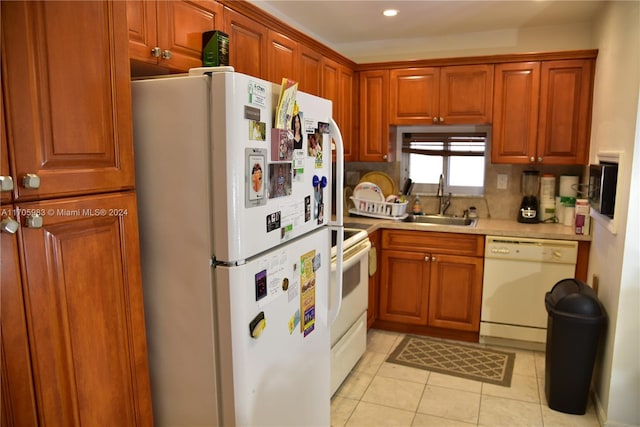 kitchen with light tile patterned flooring, white appliances, tasteful backsplash, and sink