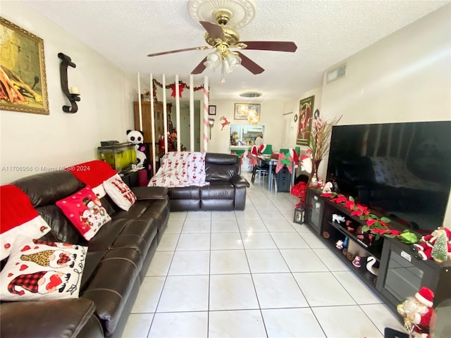 tiled living room with ceiling fan and a textured ceiling